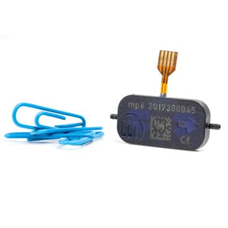 Bartels mp6-liq miniature black piezo pump next to a blue paper clip