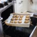 Photograph of someone putting cookies in an oven