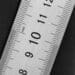 Photograph of a metal ruler on a black background